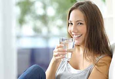 Frau auf Stuhl trinkt Wasser