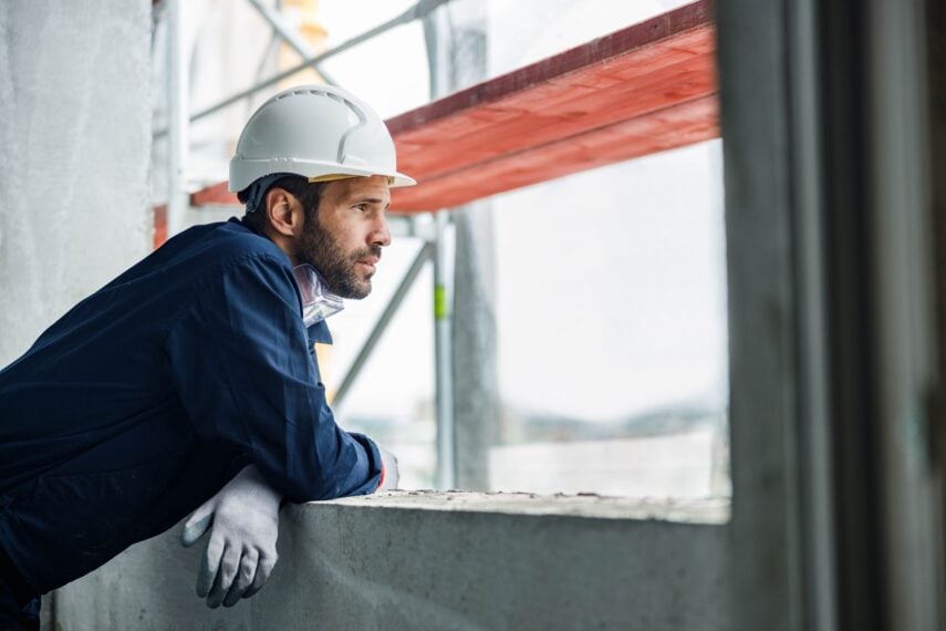 Construction worker leaning on window