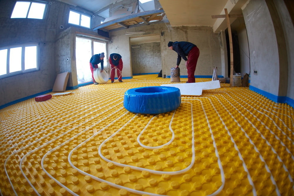 grouo of workera installing underfloor heating and colling in modern home