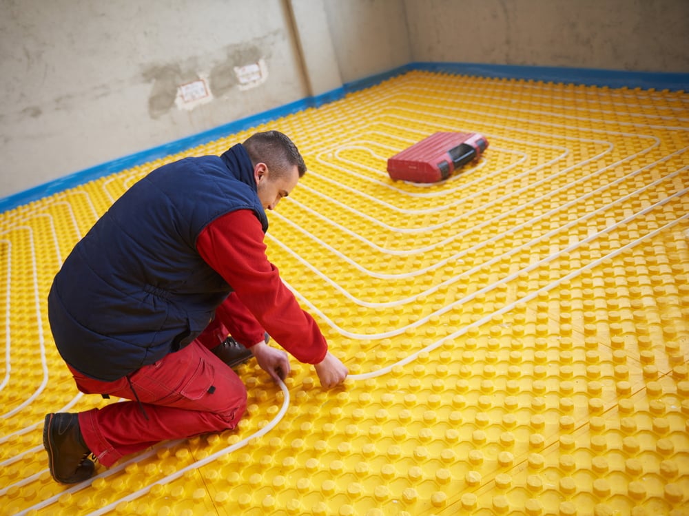 group of workera installing underfloor heating and colling in modern home
